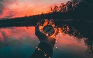 Preview wallpaper compass, garland, hand, river, evening