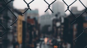 Preview wallpaper fence, grid, hole, rain, city, blur