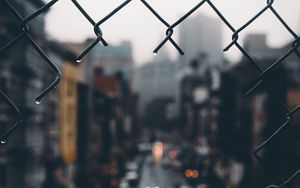 Preview wallpaper fence, grid, hole, rain, city, blur